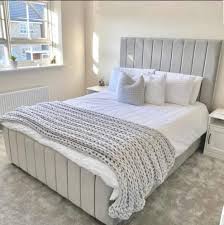 Elegant black panel headboard bed with soft gray upholstery and white bedding in a modern bedroom