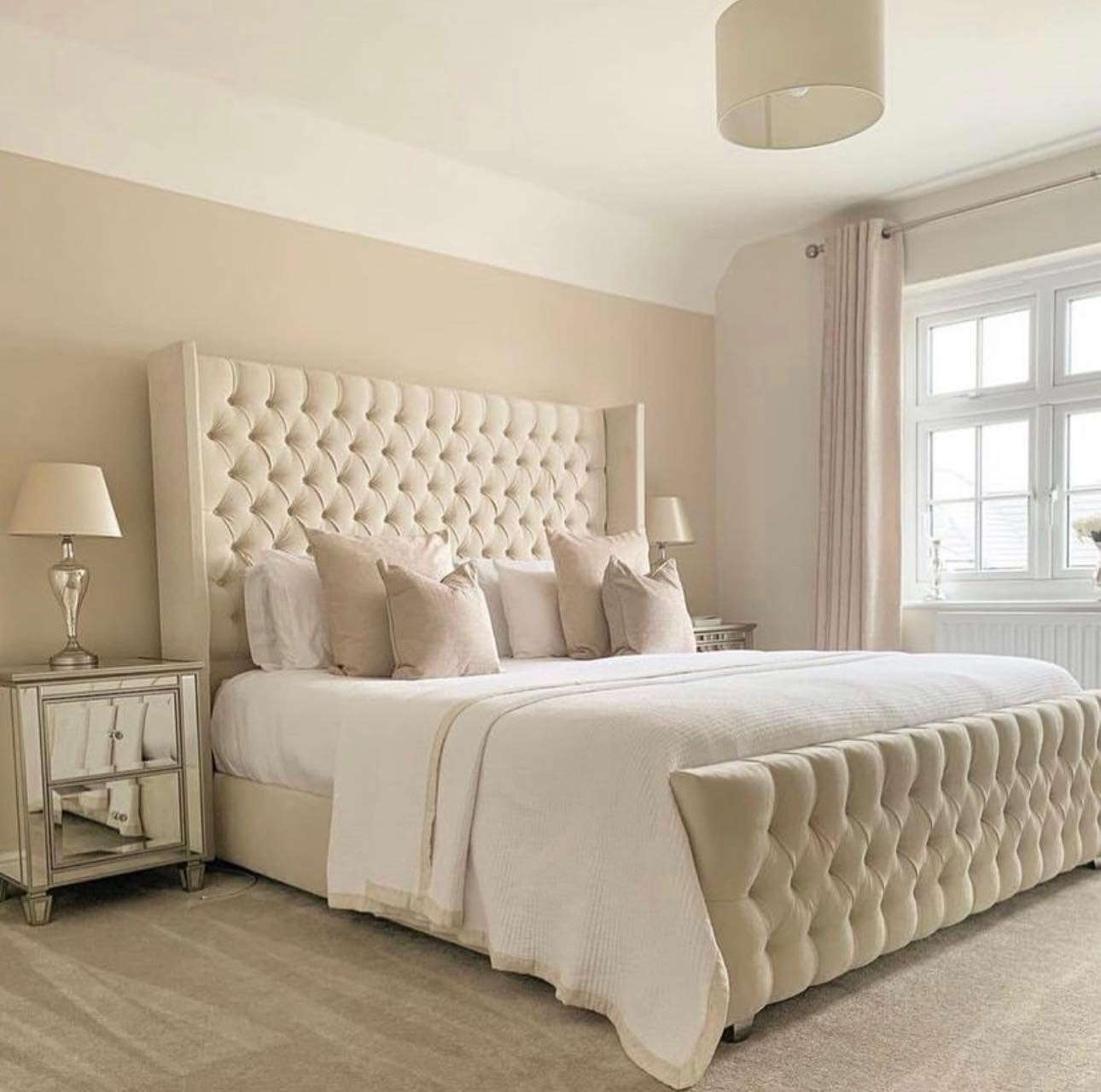 Elegant beige chesterfield wingback bed with tufted headboard and footboard in a cozy bedroom