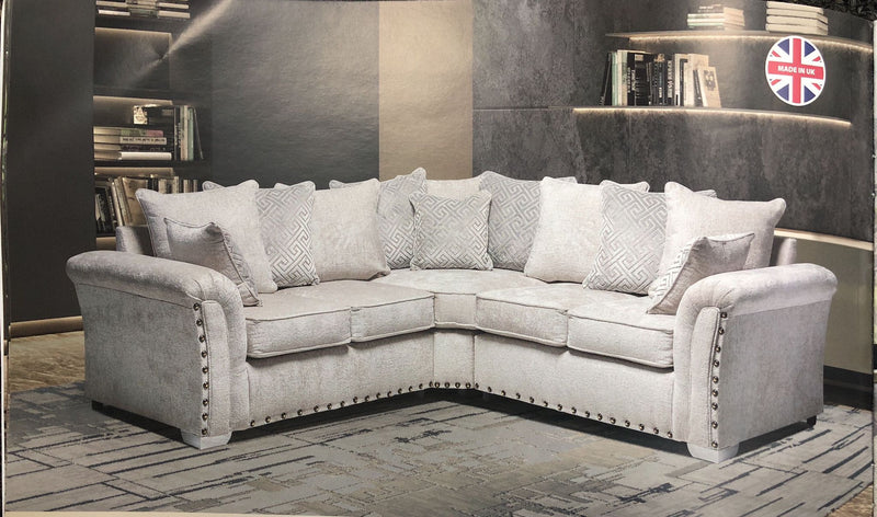 Comfortable L shaped sofa UK in light gray fabric with plush cushions and studded armrests by Furnish UK