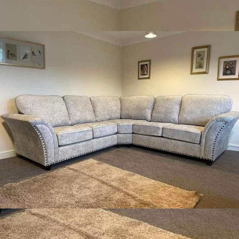 Furnish UK comfortable L shaped sofa UK in light grey fabric with cushioned seats in a cozy living room