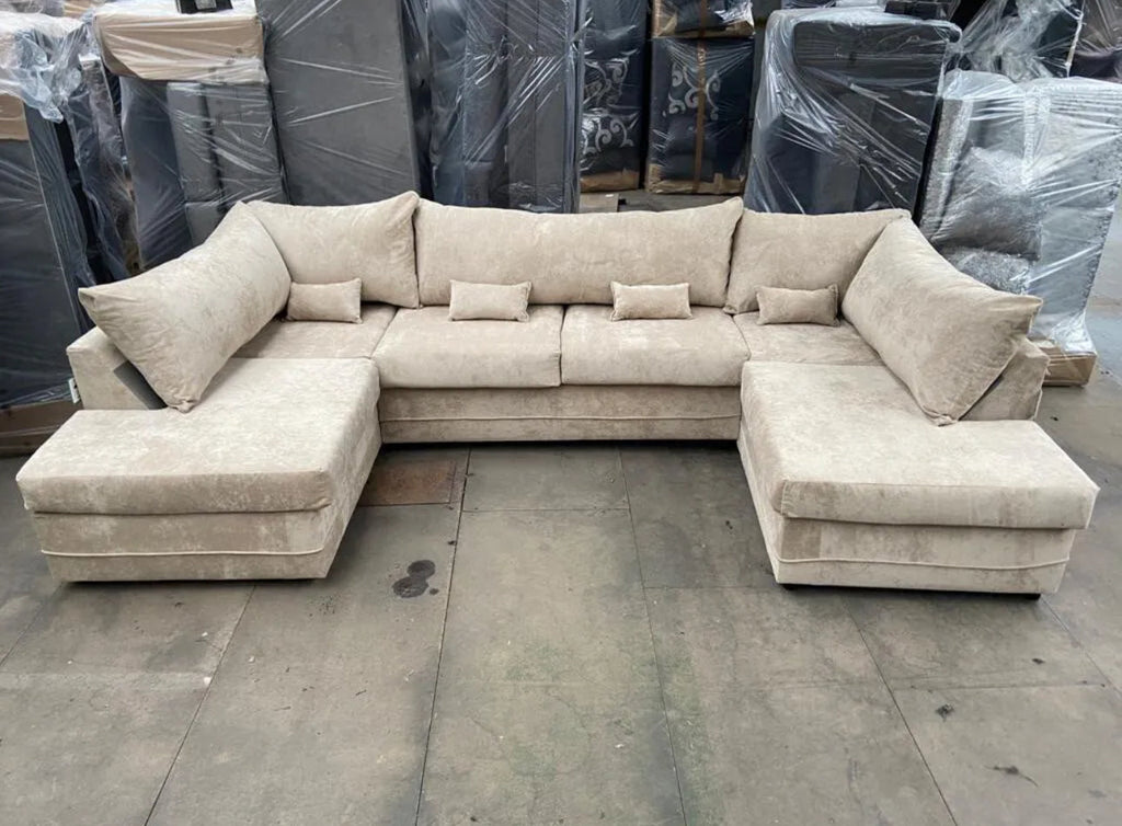 Beige large U shaped sofa with chaise by Furnish UK in a warehouse setting
