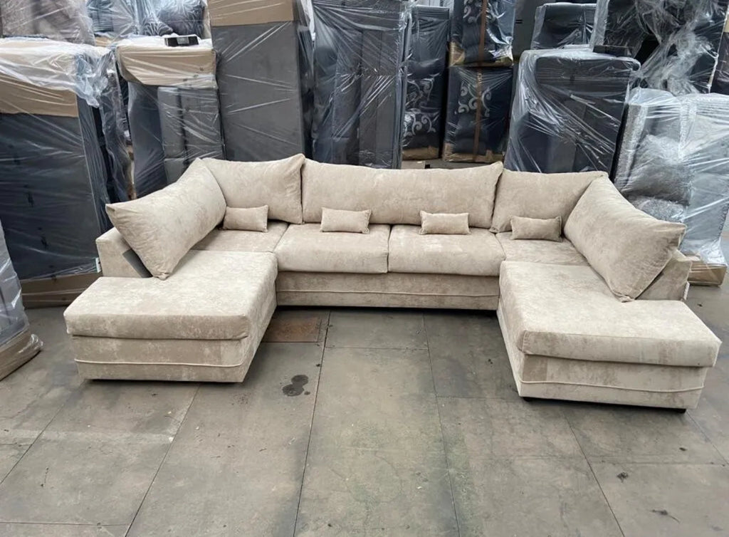 Large U shaped sofa with chaise in beige fabric featuring multiple cushions by Furnish UK