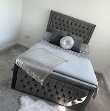 Luxury velvet bed frame by Furnish UK in dark gray with tufted headboard and footboard in a modern bedroom