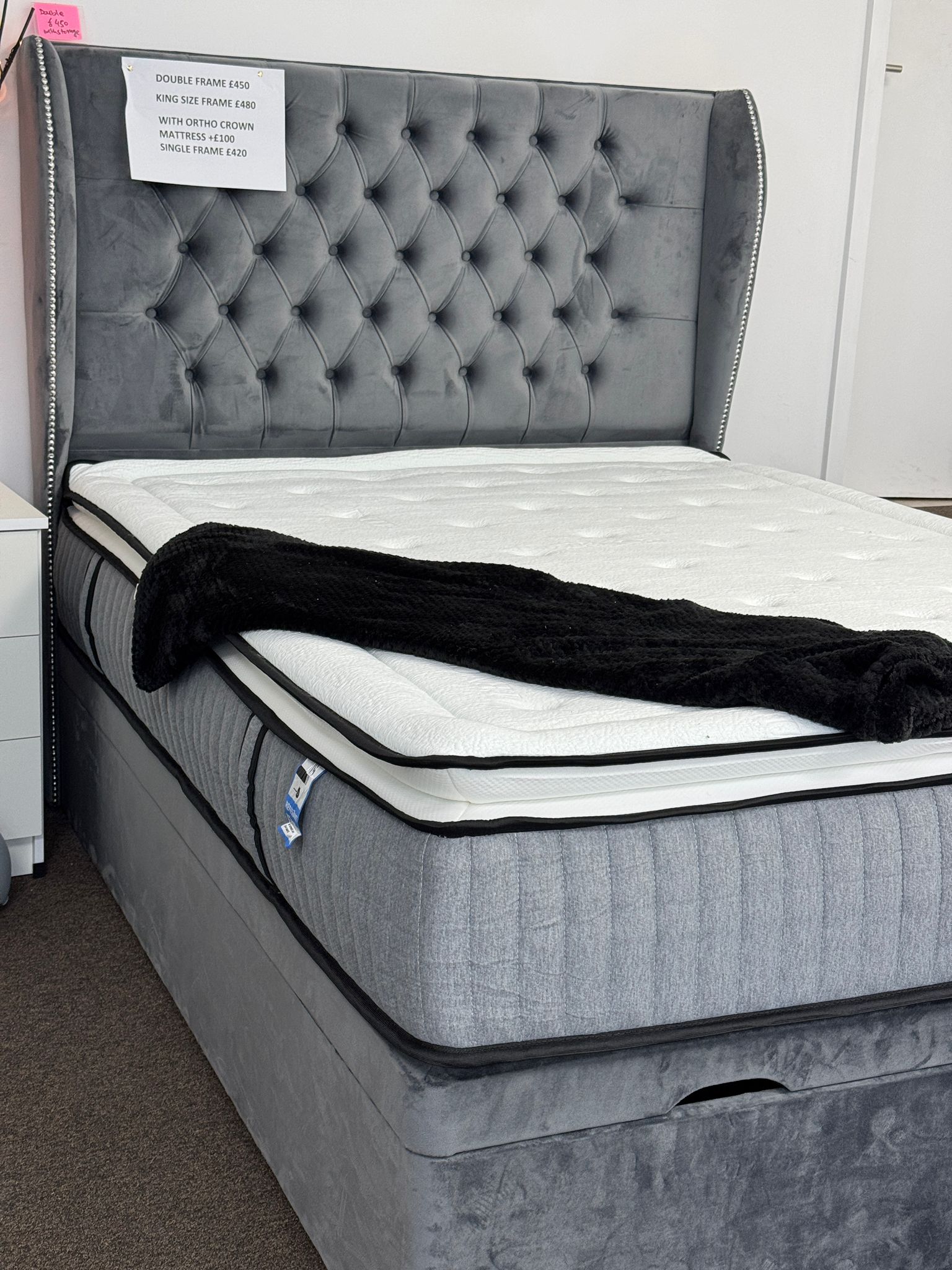 Gray velvet ottoman divan bed with storage featuring tufted headboard and white mattress