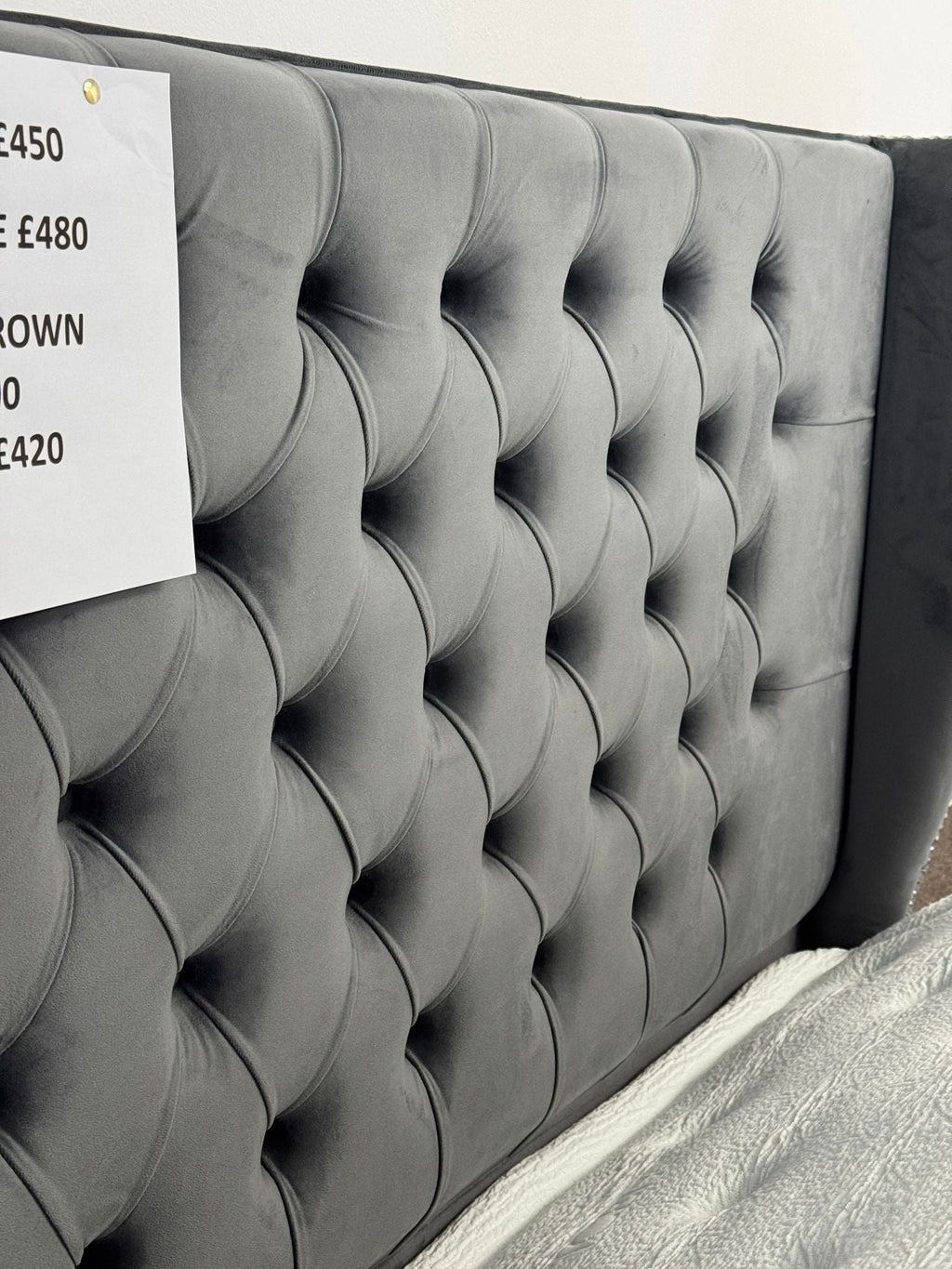 Gray tufted headboard of an ottoman divan bed with storage by Furnish UK