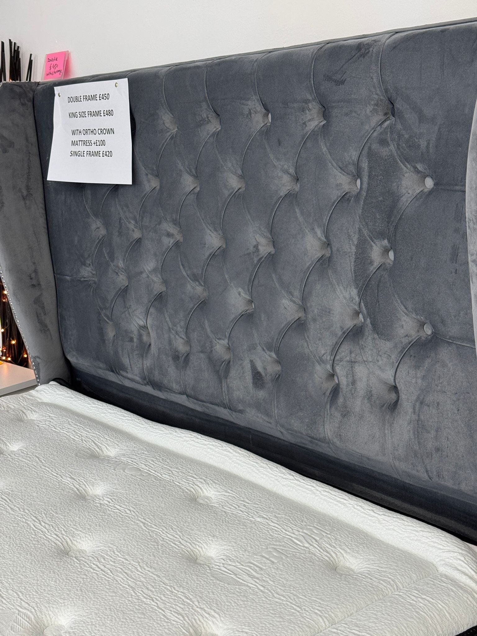 Furnish UK ottoman divan bed with storage featuring a tufted dark gray upholstered headboard and white mattress