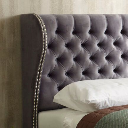 Close-up of a tufted grey velvet headboard on an ottoman divan bed with storage from Furnish UK