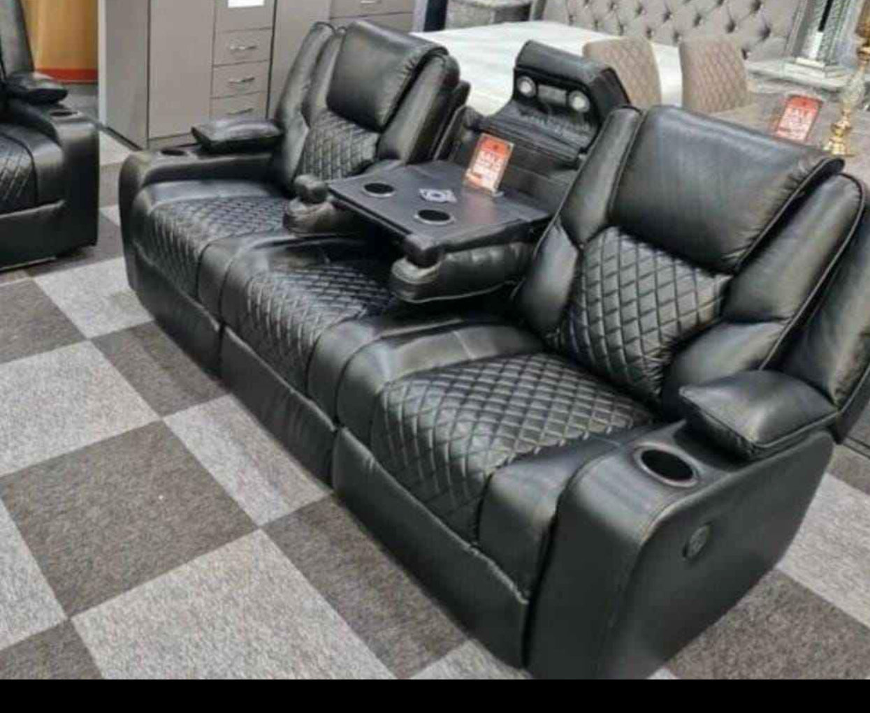 Furnish UK black electric leather recliner sofa with quilted seats and built-in cup holders