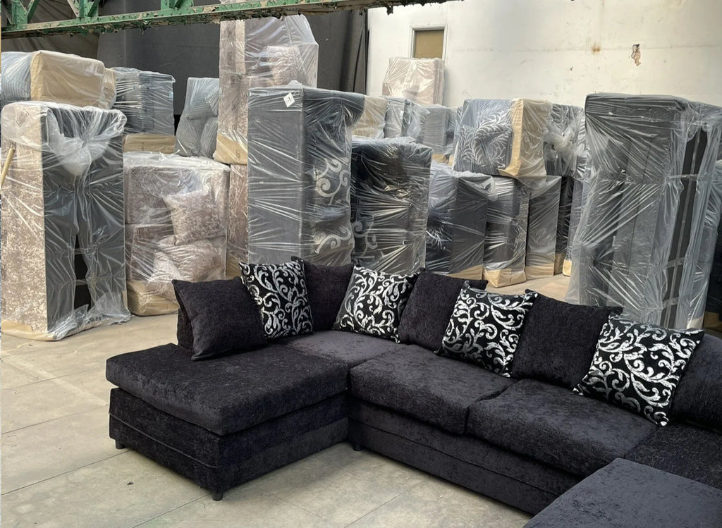 Furnish UK U shape fabric sofa with cushions in dark fabric with patterned throw pillows in warehouse